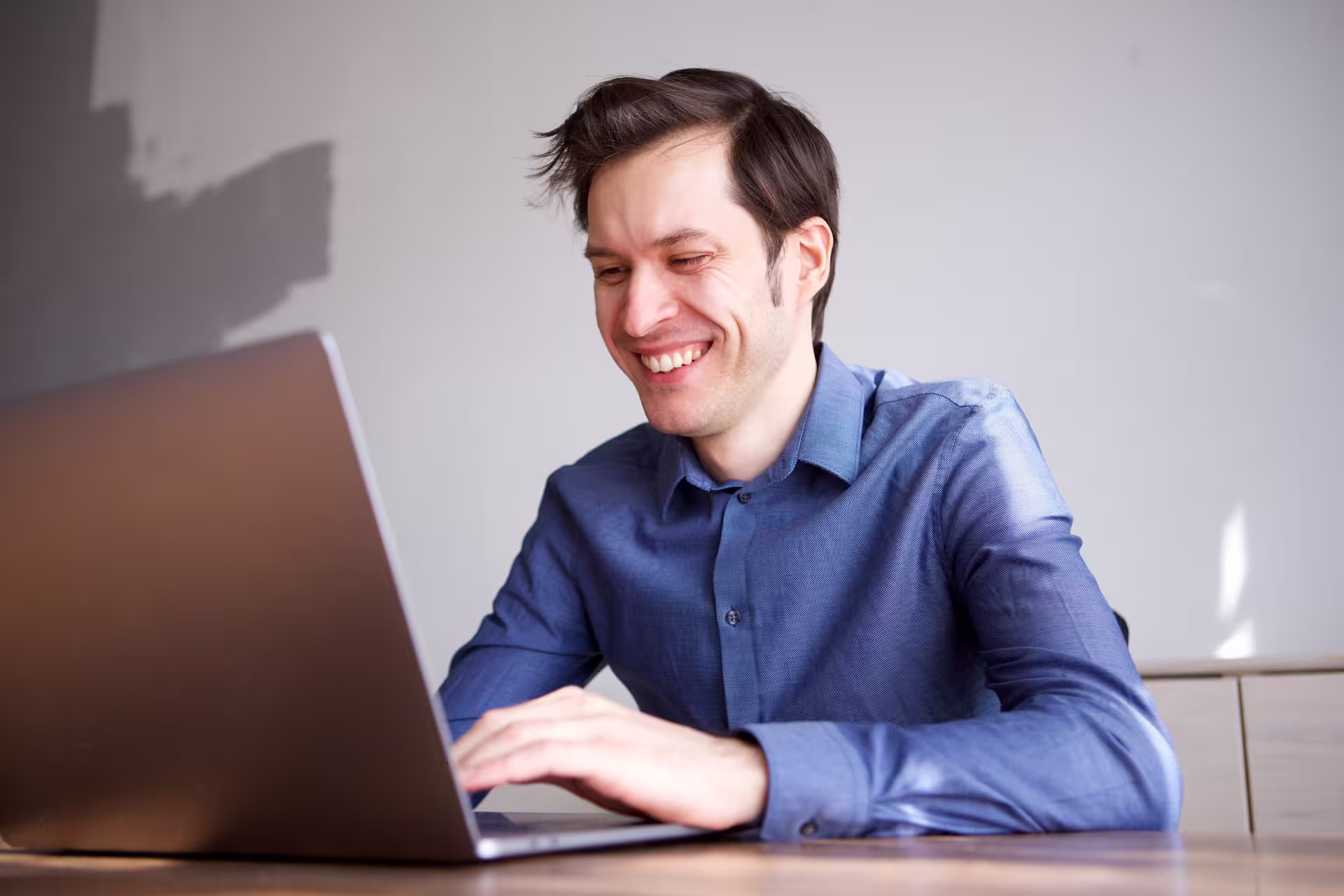 Un hombre con un ordenador portátil sonriendo